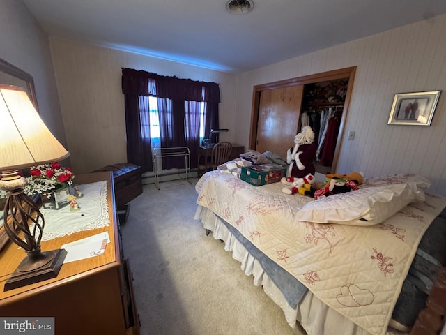 carpeted bedroom featuring a closet and wooden walls