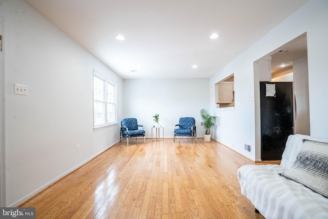 living area with light hardwood / wood-style floors and heating unit