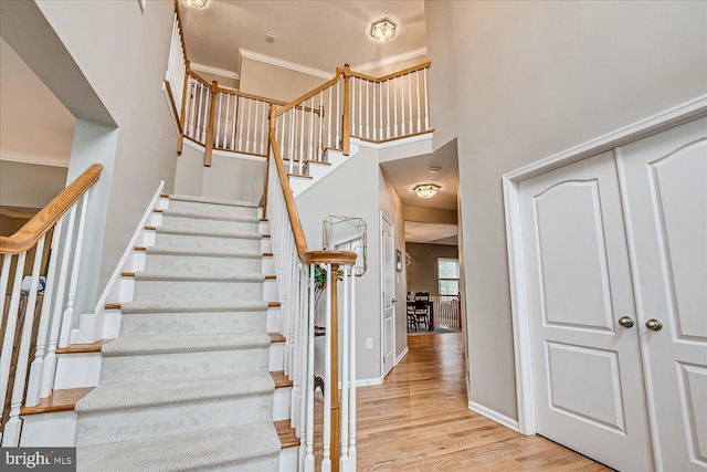 staircase featuring crown molding and wood-type flooring