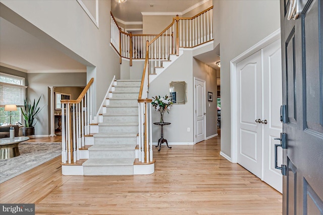 entryway with crown molding and light wood-type flooring