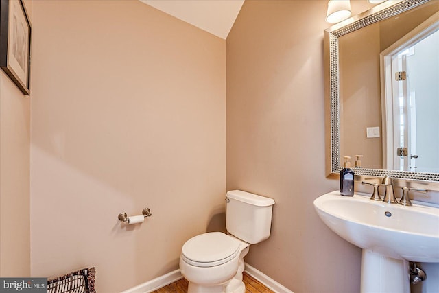 bathroom featuring sink, toilet, and lofted ceiling