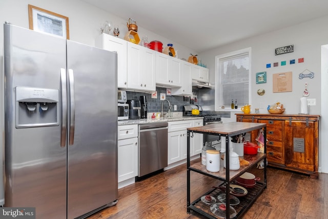 kitchen with white cabinetry, stainless steel appliances, dark wood-type flooring, and decorative backsplash