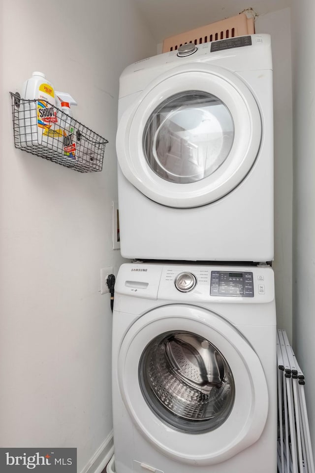 clothes washing area featuring stacked washer / dryer