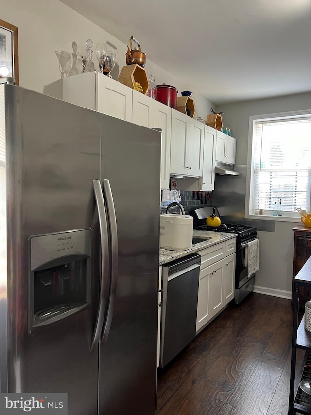 kitchen with sink, stainless steel appliances, dark hardwood / wood-style floors, light stone countertops, and white cabinets