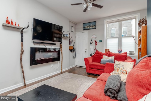 living room featuring dark wood-type flooring and ceiling fan