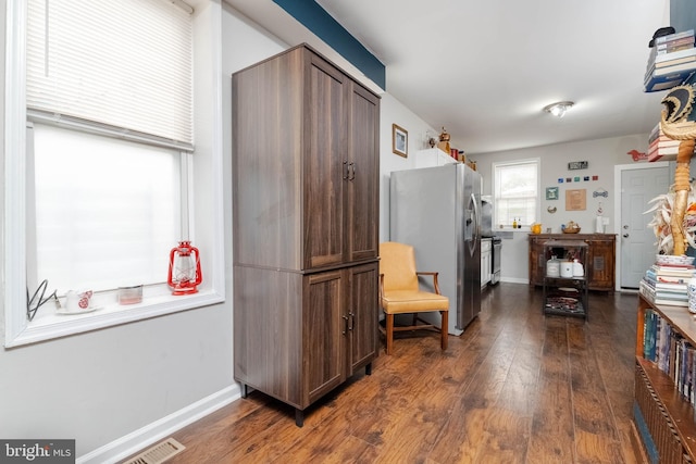 kitchen featuring dark hardwood / wood-style flooring, stainless steel fridge, and dark brown cabinetry