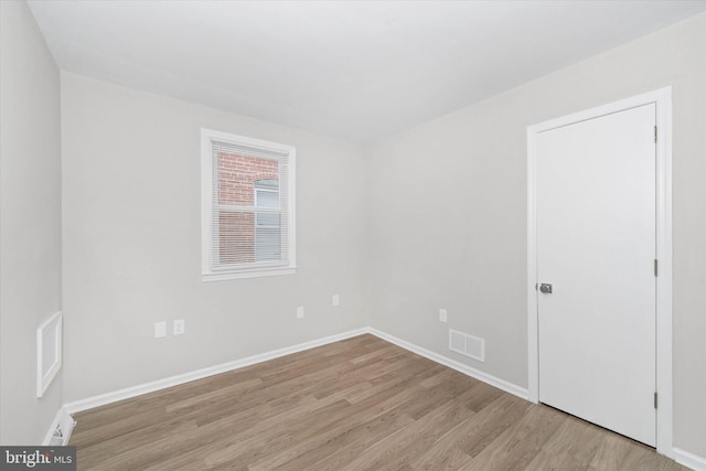 empty room with light hardwood / wood-style flooring