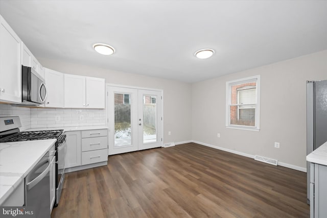 kitchen with a healthy amount of sunlight, stainless steel appliances, french doors, and white cabinetry