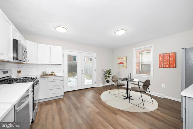 kitchen with white cabinets, french doors, dark hardwood / wood-style floors, and stainless steel appliances