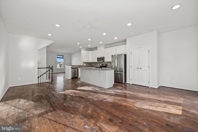 kitchen featuring stainless steel appliances, a kitchen island, white cabinets, and dark hardwood / wood-style floors