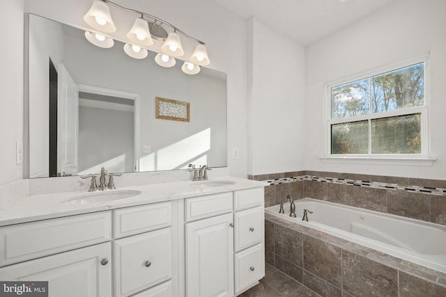 bathroom featuring tiled bath and vanity