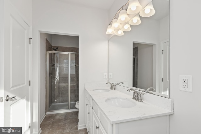 bathroom with toilet, a shower with door, and vanity