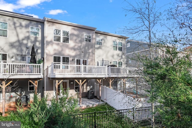 rear view of house featuring cooling unit, a deck, and a patio