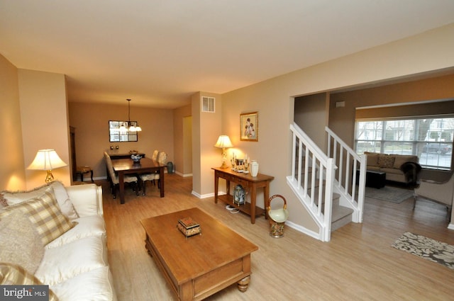 living room featuring an inviting chandelier and wood-type flooring