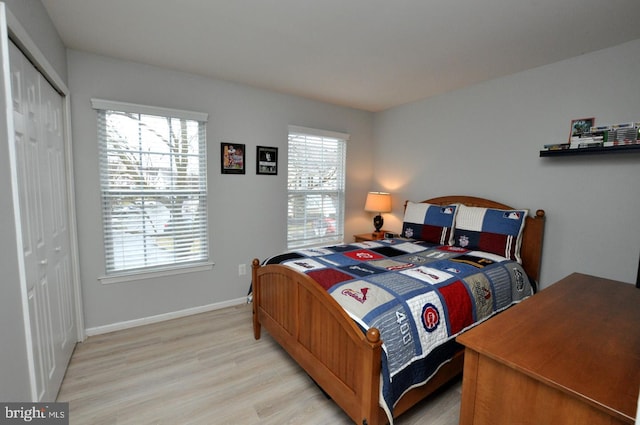 bedroom with light wood-type flooring and a closet