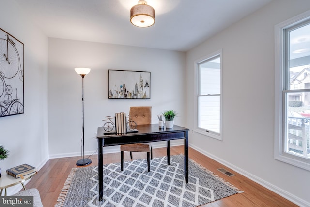 office featuring wood finished floors, visible vents, and baseboards