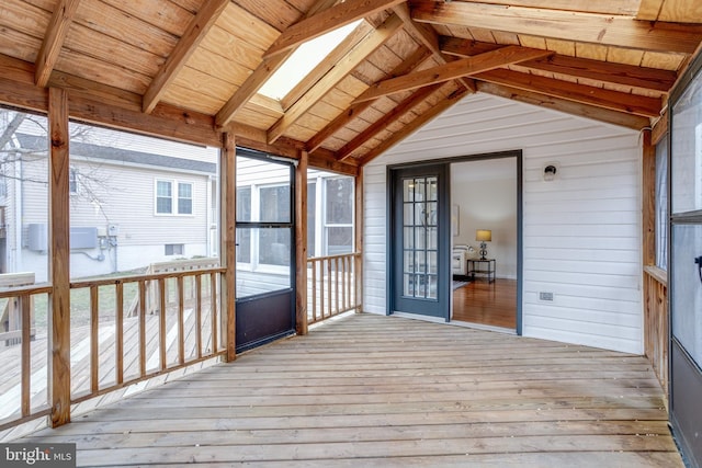 unfurnished sunroom with vaulted ceiling with skylight