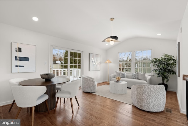 living room with lofted ceiling, wood-type flooring, and a healthy amount of sunlight