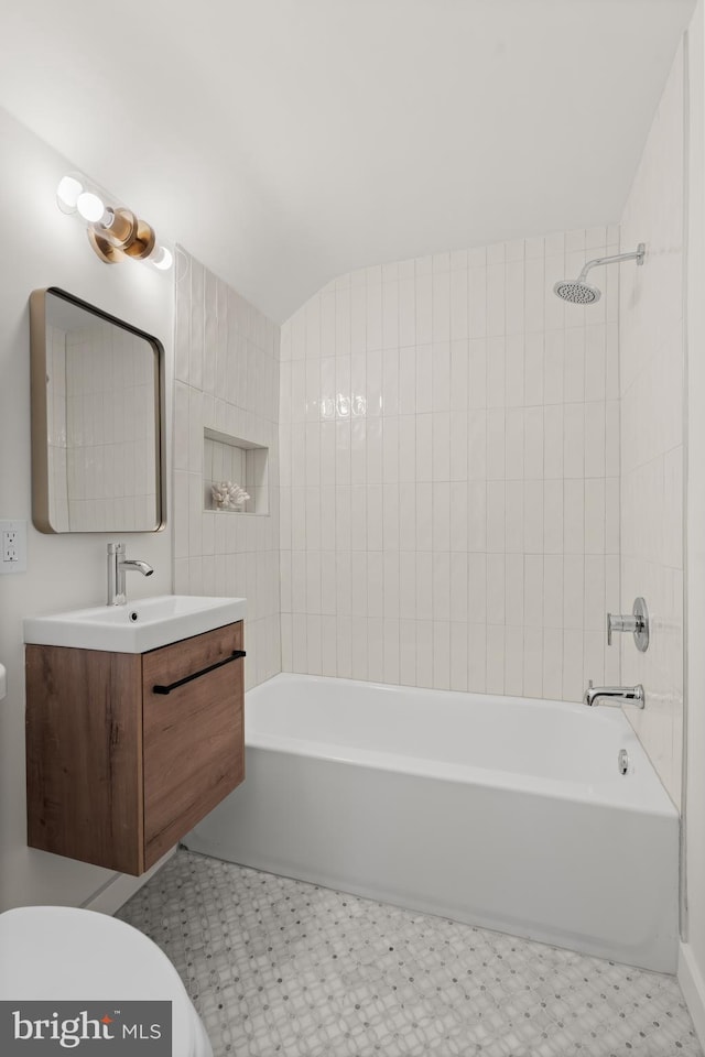 full bathroom featuring toilet, tiled shower / bath combo, and vanity