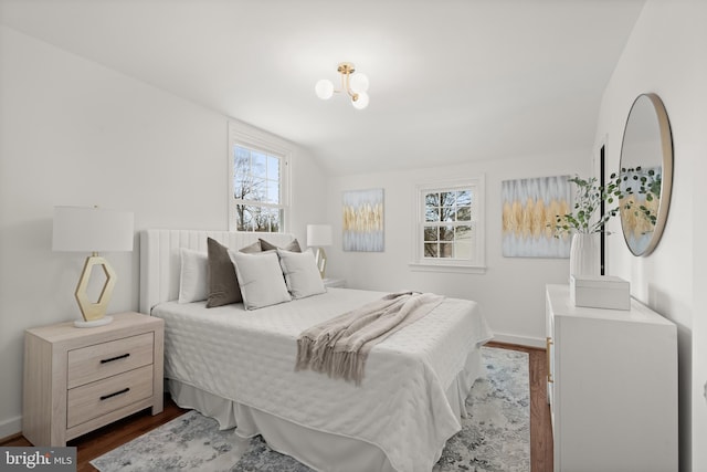 bedroom featuring dark wood-type flooring and vaulted ceiling