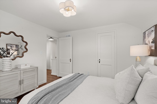 bedroom with dark wood-type flooring and a chandelier