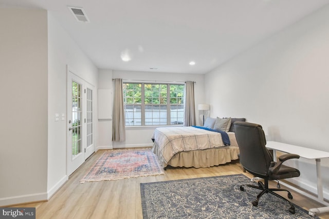 bedroom with french doors, access to exterior, and light hardwood / wood-style floors