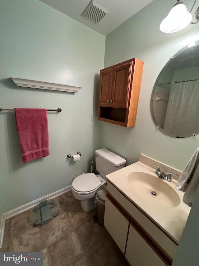 bathroom featuring walk in shower, vanity, and toilet