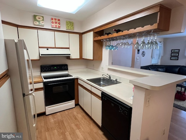 kitchen featuring kitchen peninsula, dishwasher, range with electric cooktop, white refrigerator, and sink