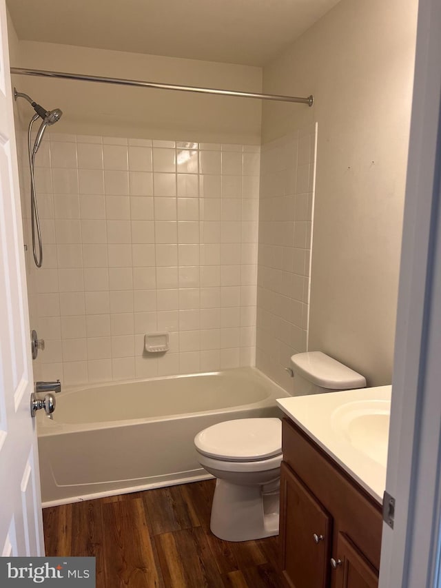 full bathroom with toilet, wood-type flooring, vanity, and tiled shower / bath