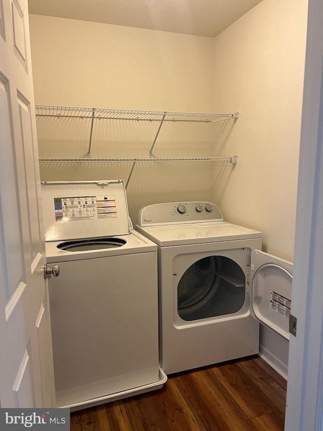 laundry area featuring washing machine and clothes dryer and dark wood-type flooring