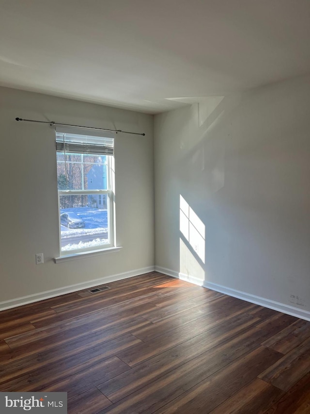 empty room with dark hardwood / wood-style flooring