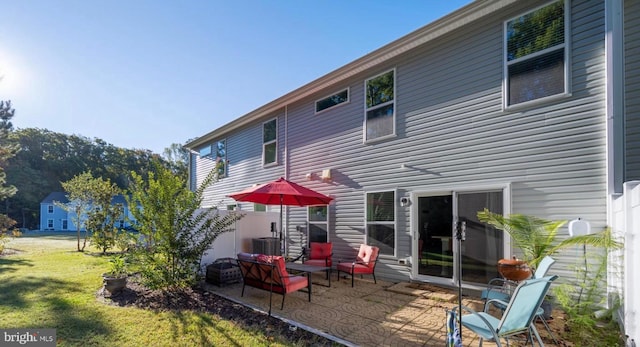 rear view of property with a lawn and a patio