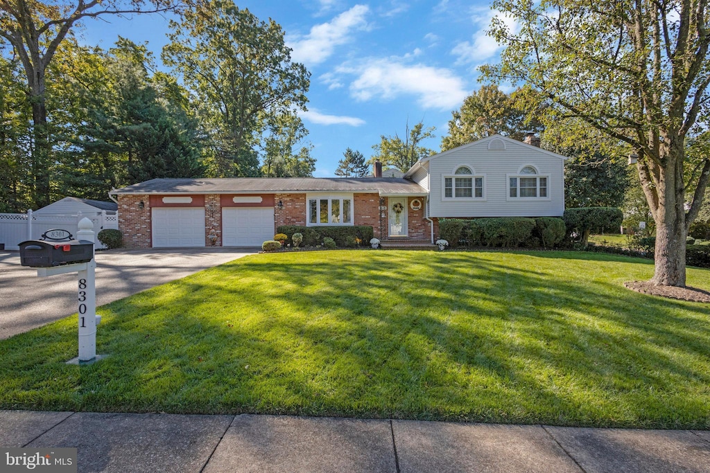 tri-level home featuring a front yard and a garage