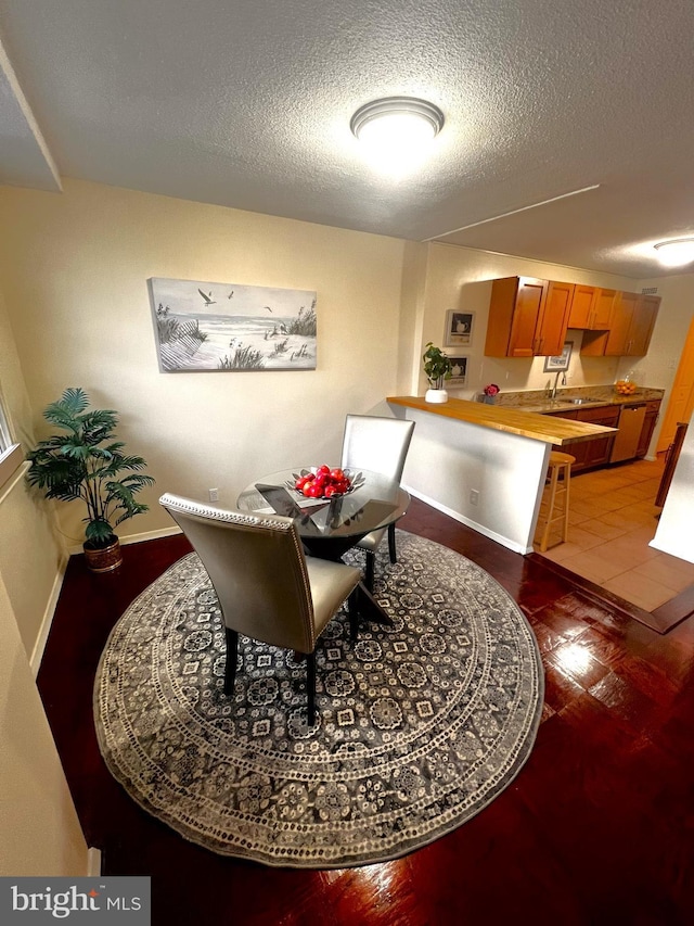 dining area featuring sink and a textured ceiling