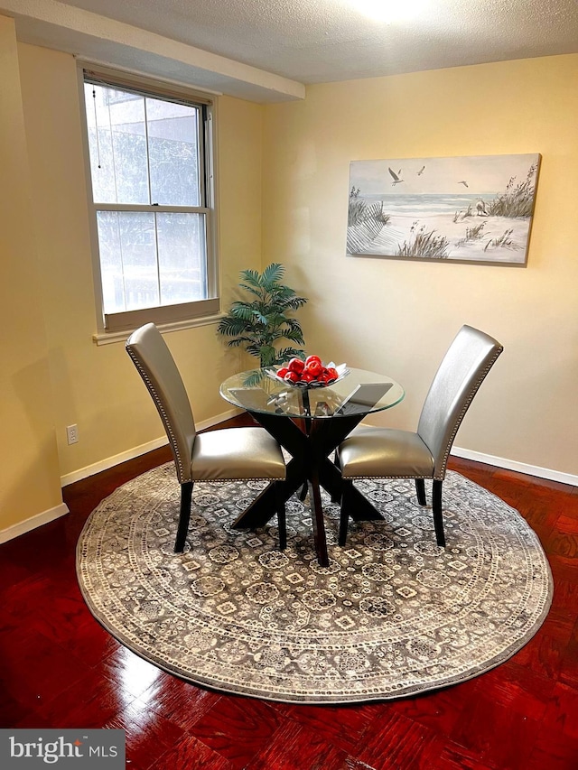 dining space featuring hardwood / wood-style floors and a textured ceiling