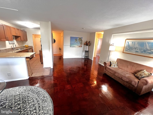 living room featuring sink and a textured ceiling