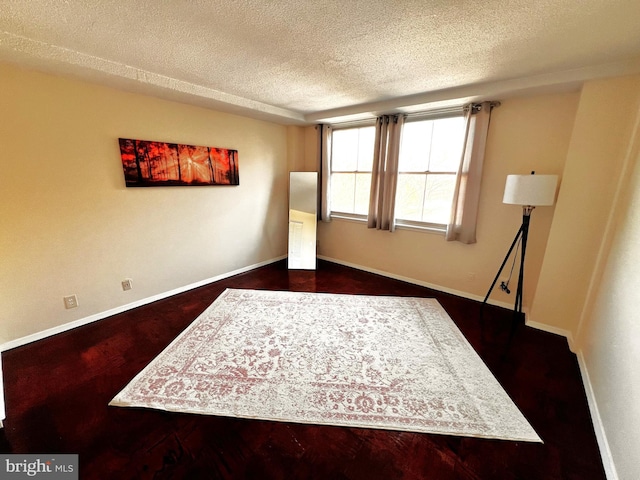 unfurnished room featuring dark hardwood / wood-style floors and a textured ceiling