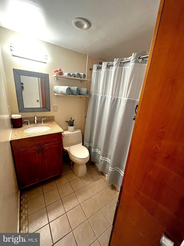 bathroom featuring vanity, tile patterned floors, and toilet