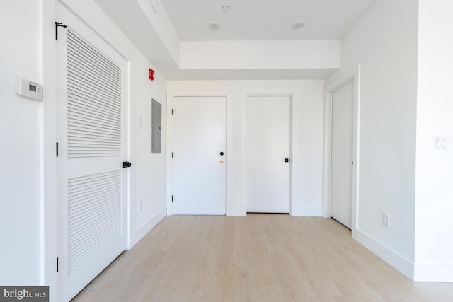 unfurnished bedroom featuring electric panel and light hardwood / wood-style floors