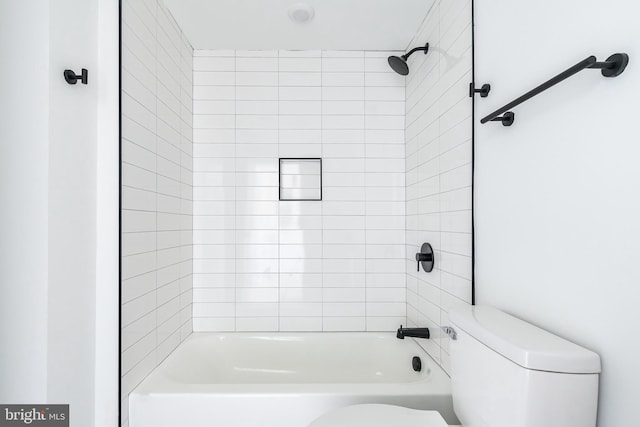 bathroom with toilet and tiled shower / bath