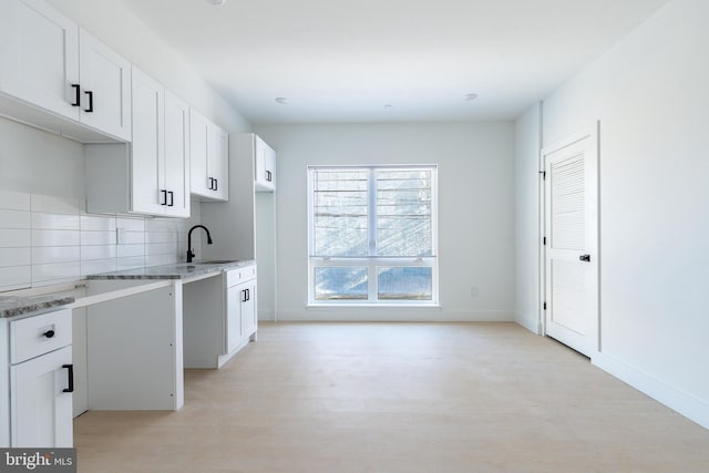 kitchen featuring sink, white cabinets, and decorative backsplash