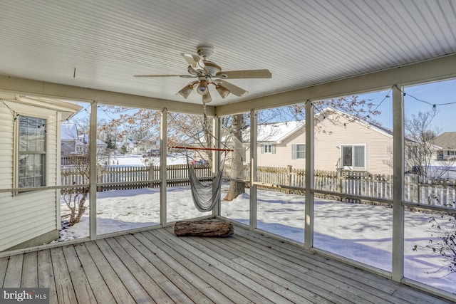 unfurnished sunroom featuring ceiling fan and a healthy amount of sunlight