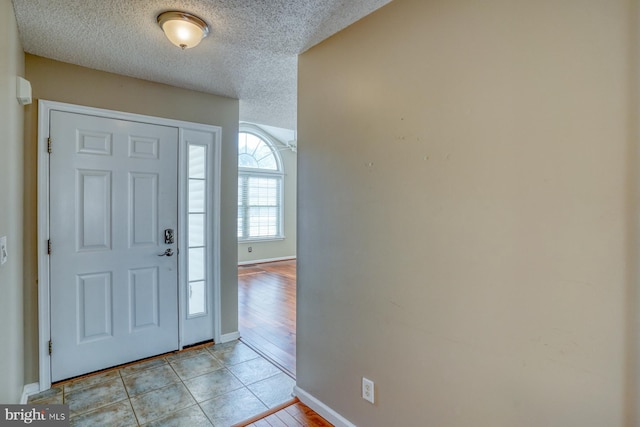 tiled entrance foyer with a textured ceiling