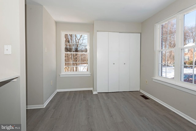 unfurnished bedroom featuring dark wood-type flooring and a closet