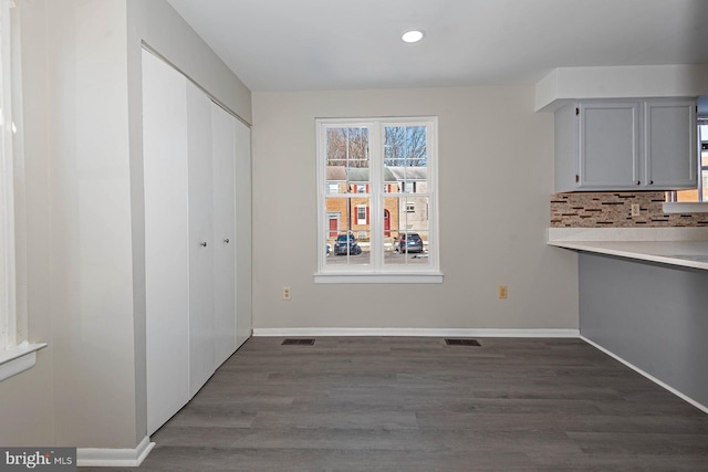 unfurnished dining area featuring dark hardwood / wood-style flooring