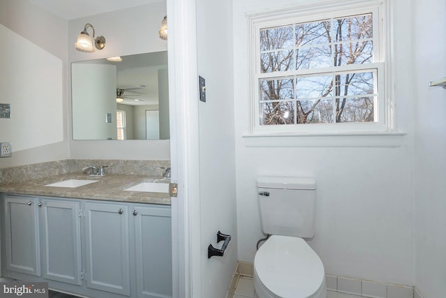 bathroom featuring toilet, vanity, tile patterned flooring, and ceiling fan