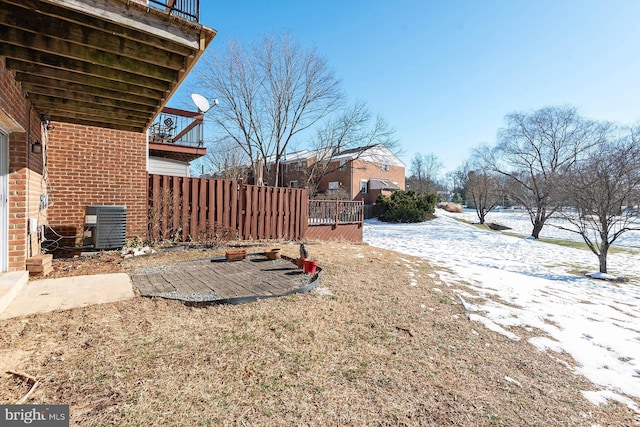 snowy yard featuring central air condition unit and a patio area