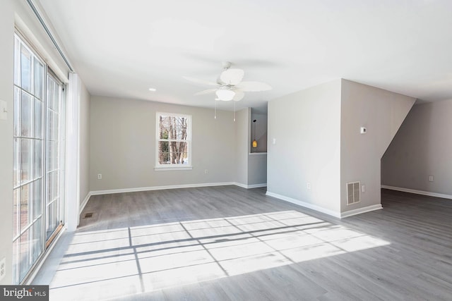 empty room with ceiling fan and light hardwood / wood-style flooring