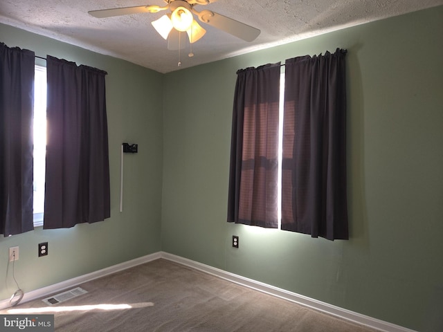 spare room with ceiling fan, a textured ceiling, and carpet flooring