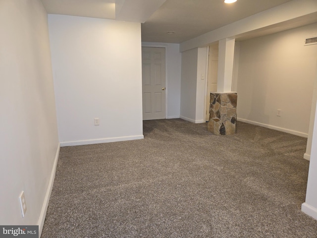 basement featuring dark colored carpet